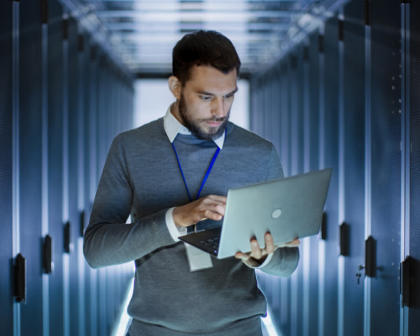 Alliance SI - Data centre disaster recovery plan Man using his laptop in data centre